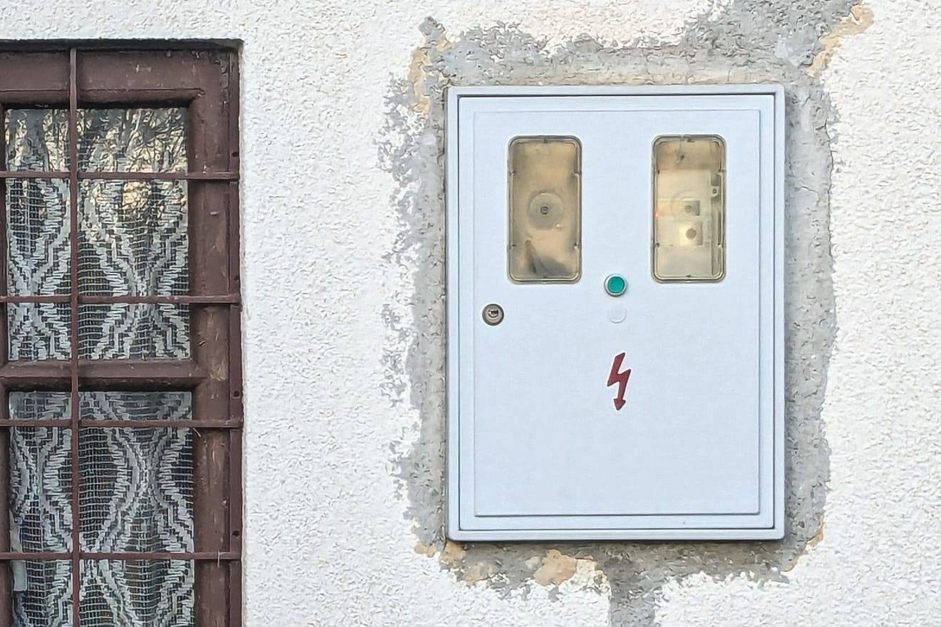 Szabványos mérőhelyszekrény két mérőablakkal egy családi ház homlokzatán
